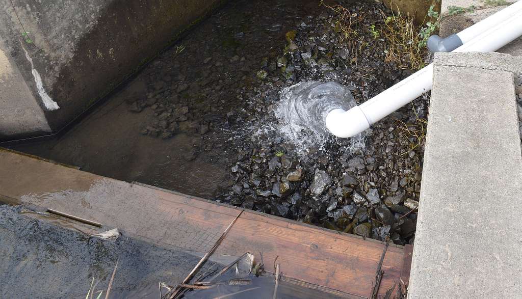 Water flowing from pipe into rocky streambed in washington