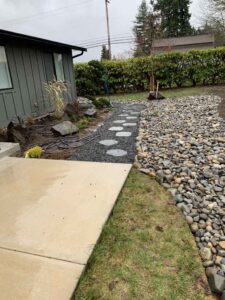 Stepping stones leading through landscaped yard with rocks