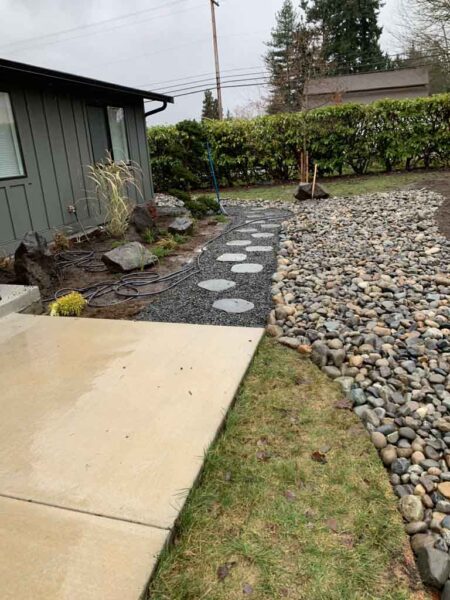 Rainy backyard with stepping stones and gravel path