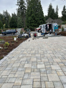 Workers installing stone paver driveway in residential area