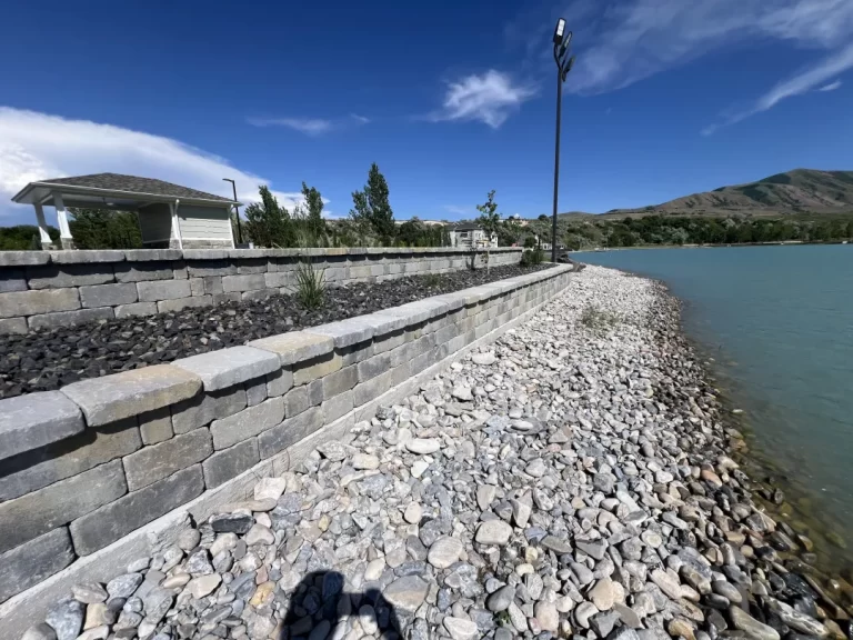 Stone retaining wall beside a calm lake