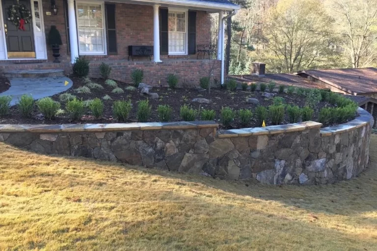 Brick house with stone retaining wall and landscaping