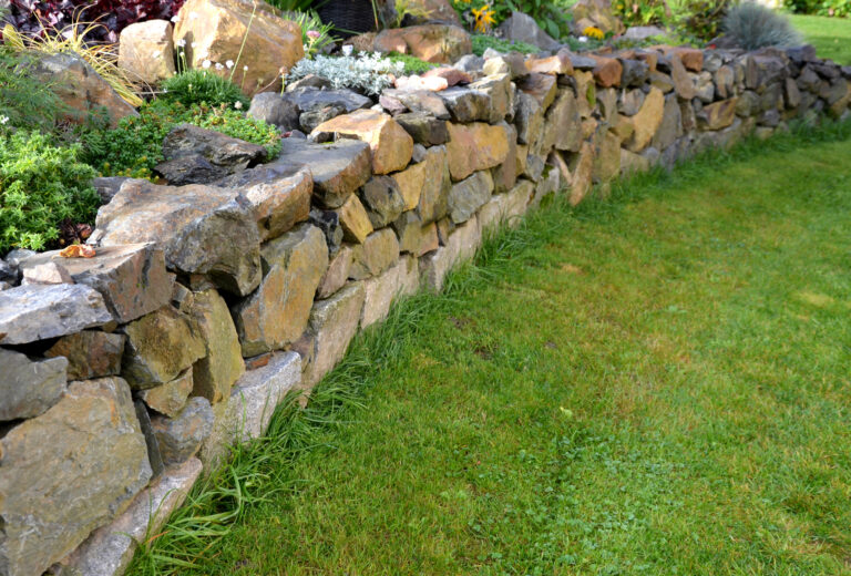 Stone garden wall with green grass